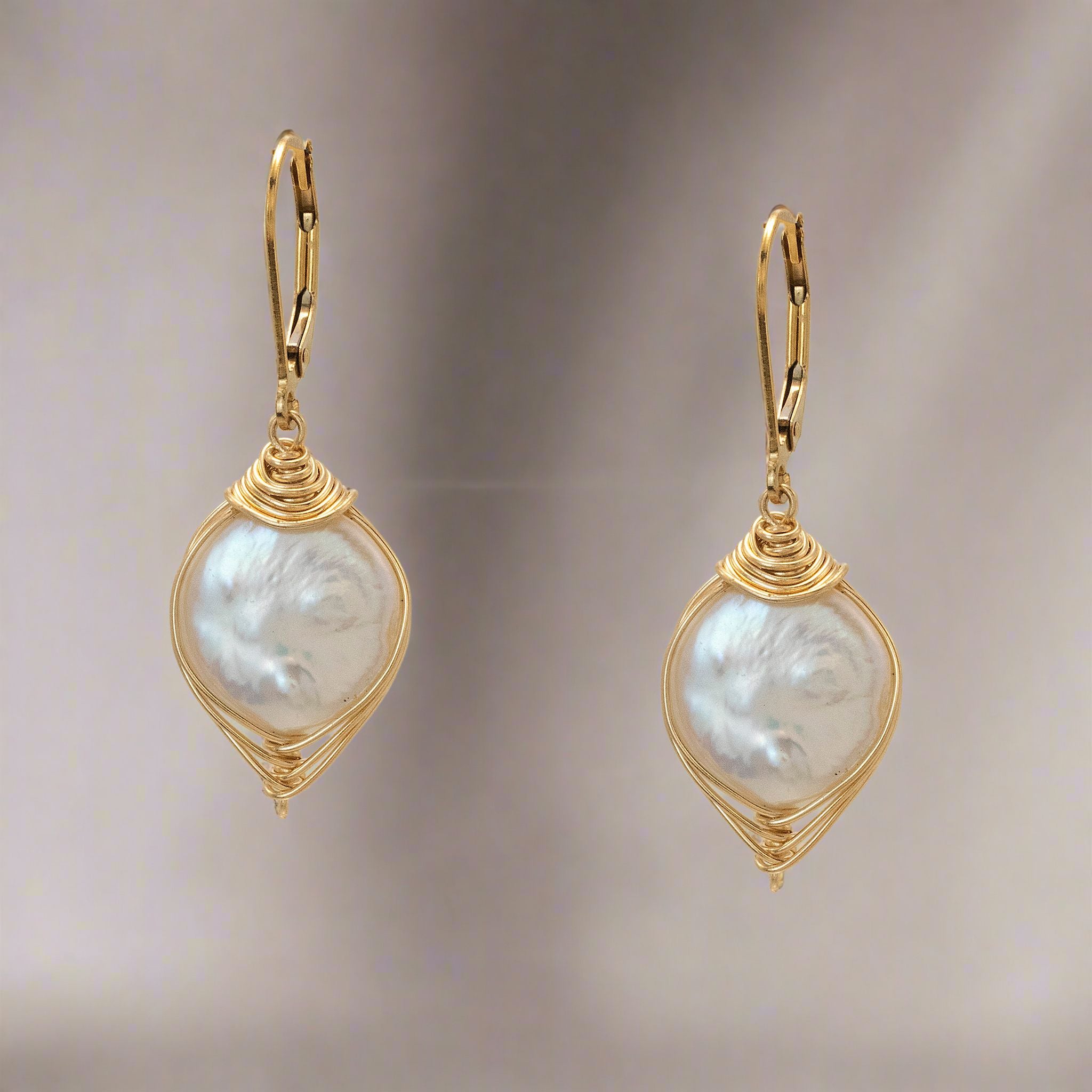A pair of gold wrapped white freshwater coin pearl earrings with 14kt gold-filled wire and lever-back hooks.