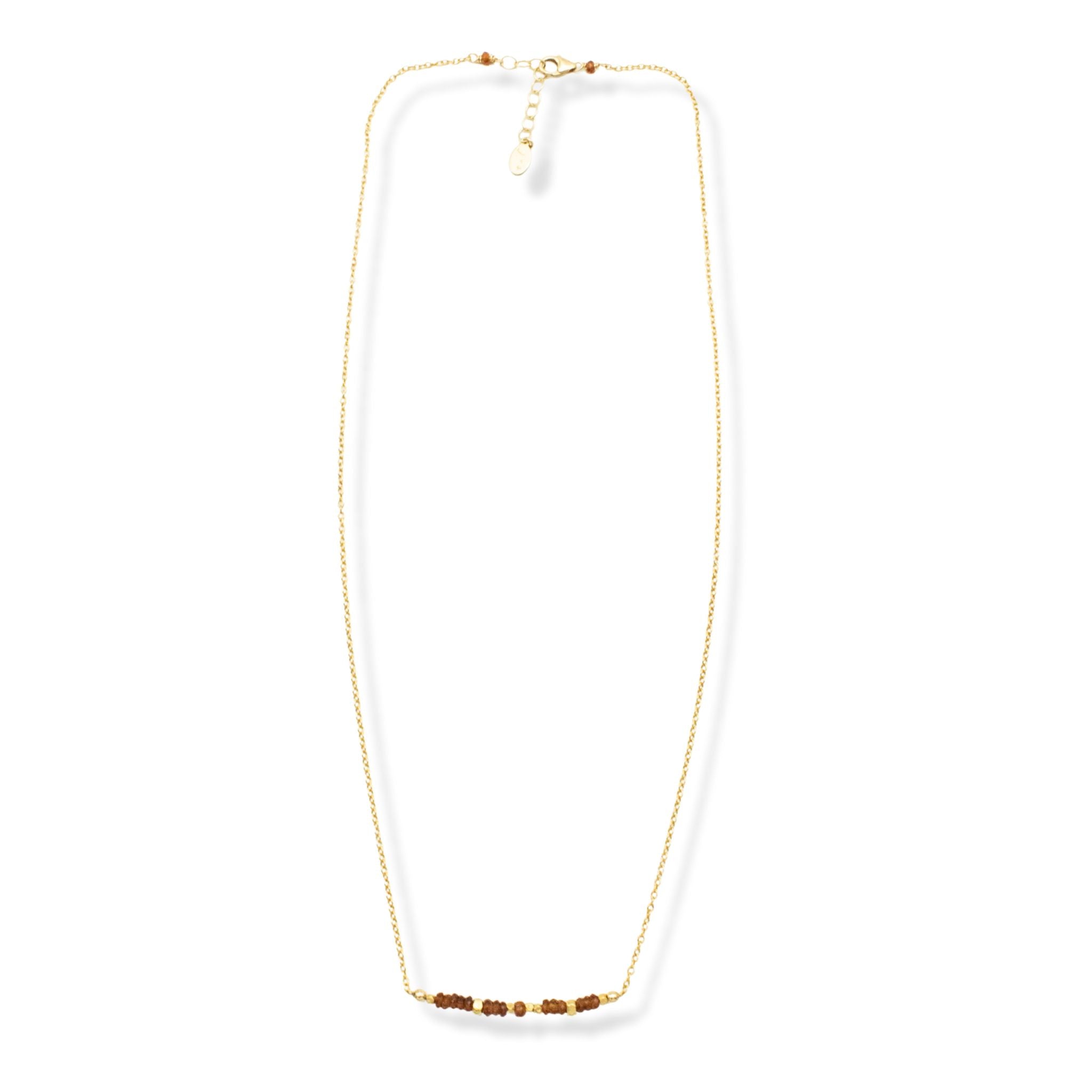 Gold necklace with brown beads on a white background